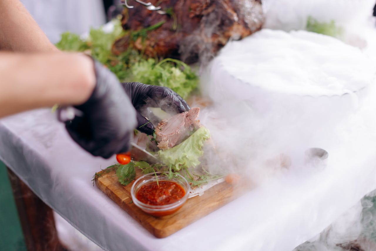 Chef preparing a gourmet meal with smoke effect and decorative ingredients on cutting board.